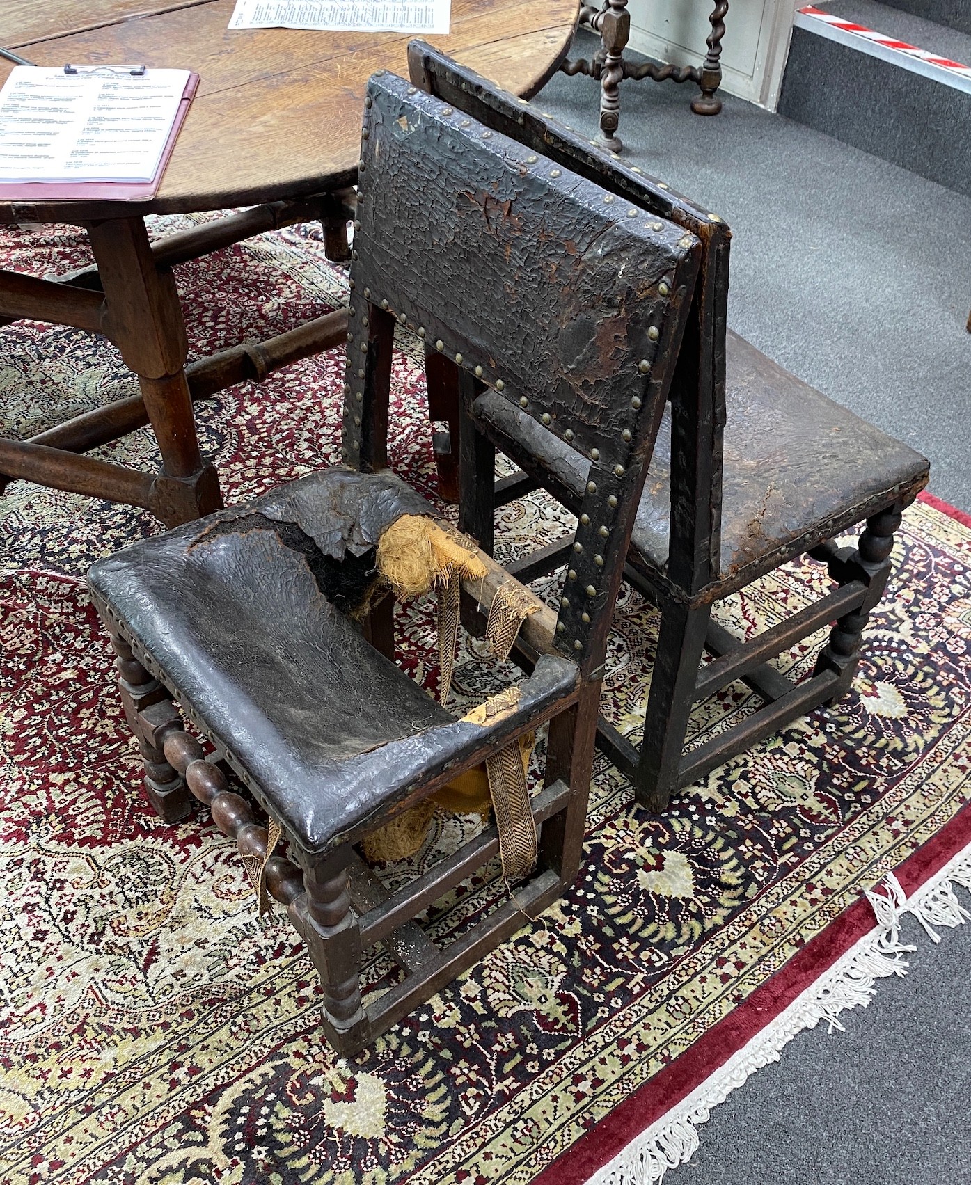 A harlequin set of six 17th century oak and leather dining chairs